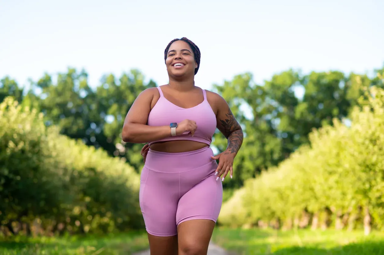 A smiling woman jogging outdoors, illustrating the meaningful weight loss seen with retatrutide in trials.