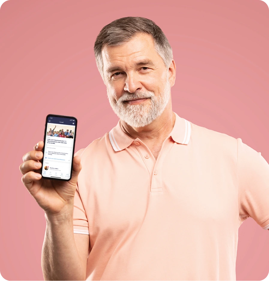 Homme barbu d'âge moyen tenant le téléphone intelligent vers la caméra, pointant vers l'appareil affichant l'écran d'accueil de l'application Constant Health.